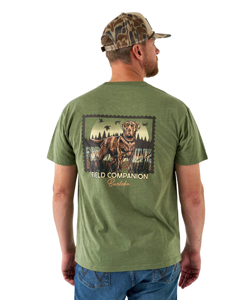 Man wearing a green t-shirt with a dog graphic and 'Field Companion' text, standing against a white background.
