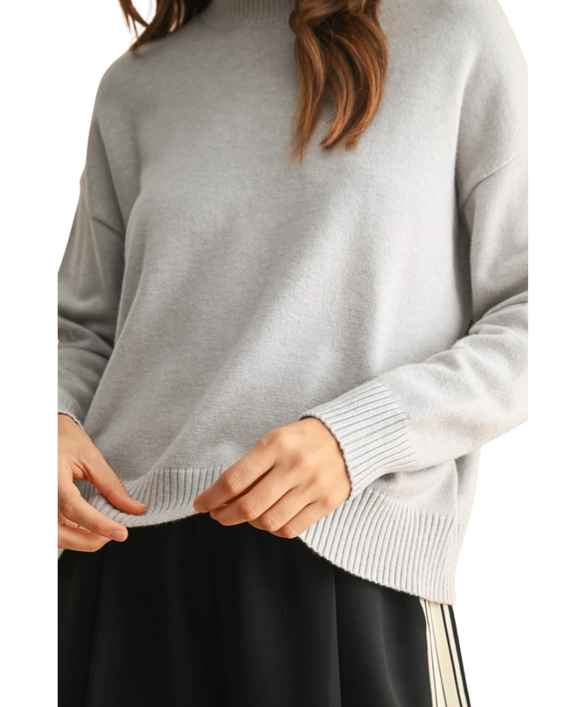 Person wearing a gray sweater with a white background