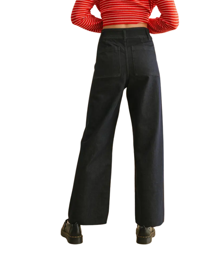 Person wearing black wide-leg pants with a red and white striped shirt on a white background