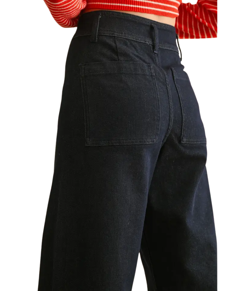 Black pants worn with a red and white striped top on a white background