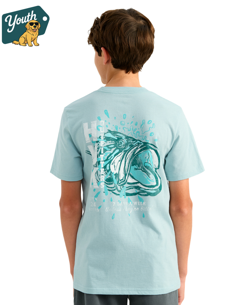 KID wearing a light blue HUK t-shirt with a bass design on the back, standing against a white background.