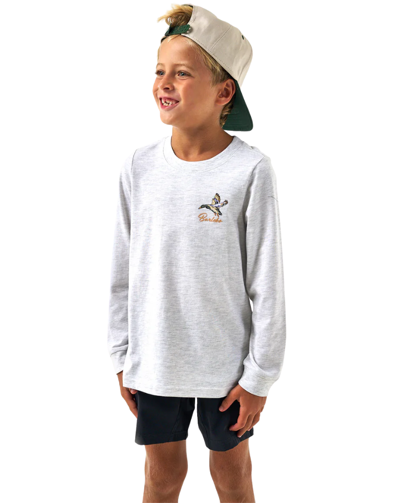 Child wearing a gray long-sleeve shirt with a logo and black shorts on a white background
