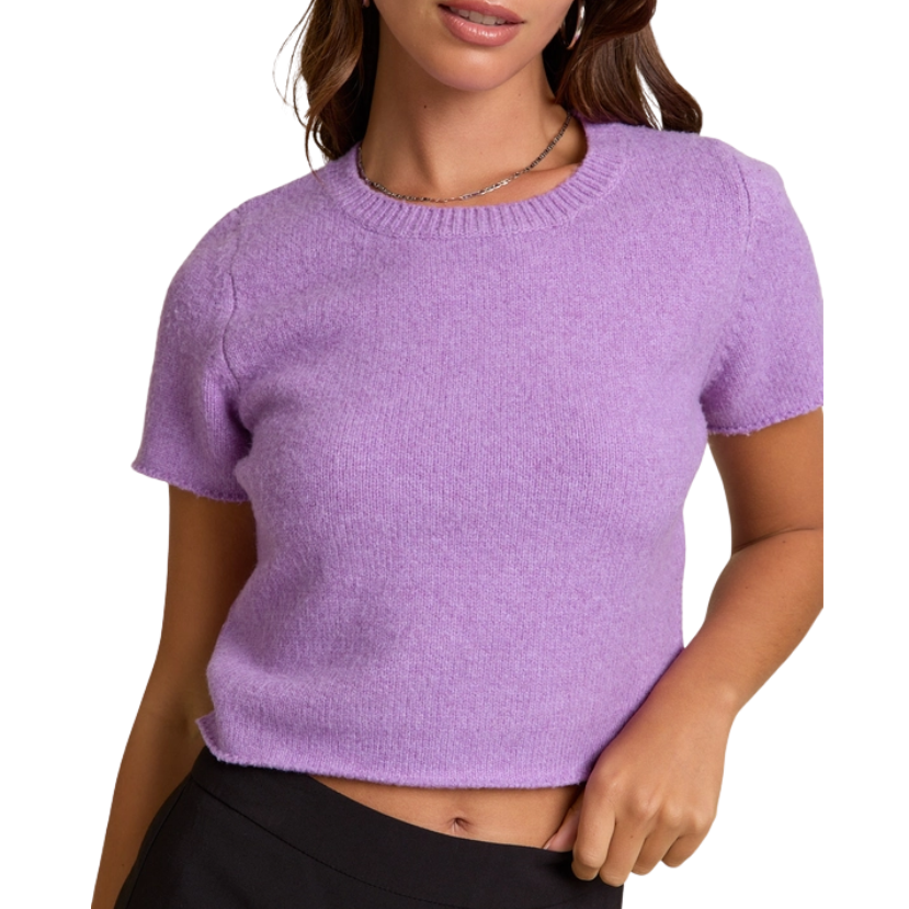 Woman wearing a purple knit top against a white background