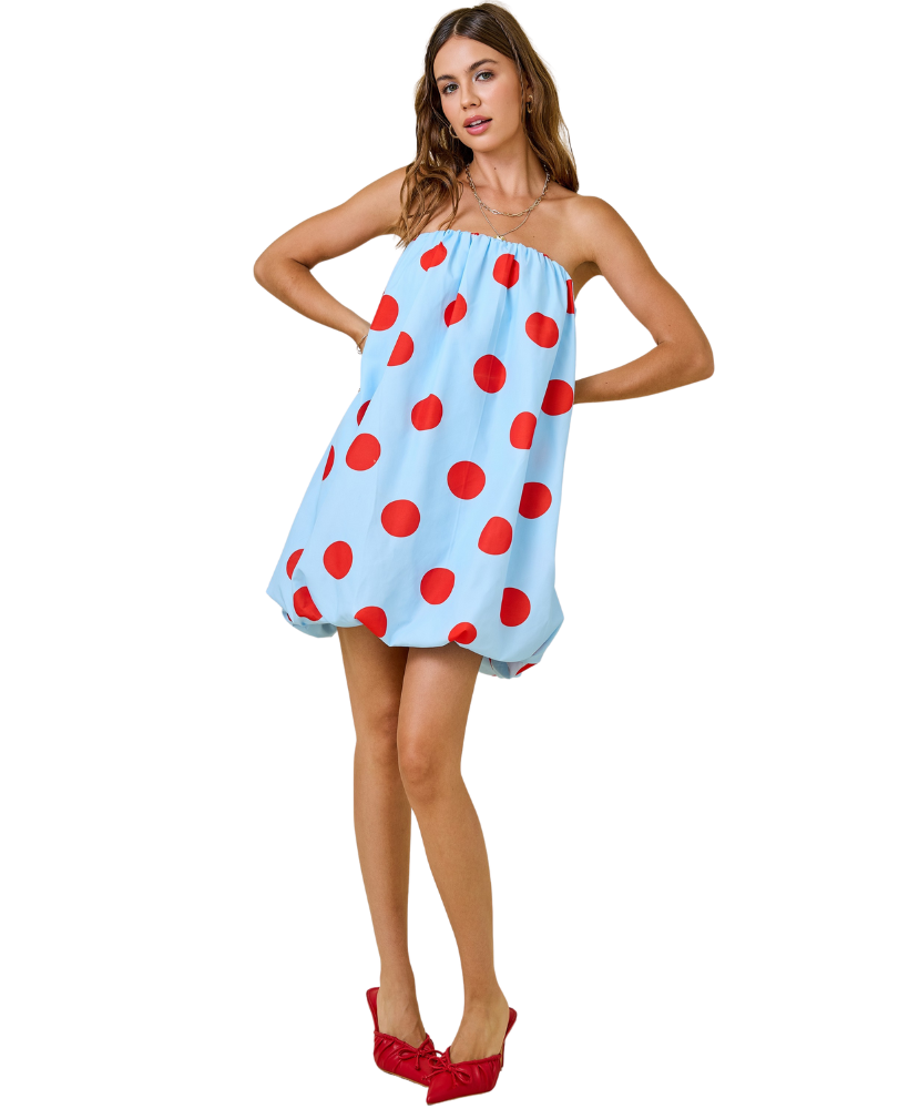 Woman wearing a strapless dress with red polka dots on a white background