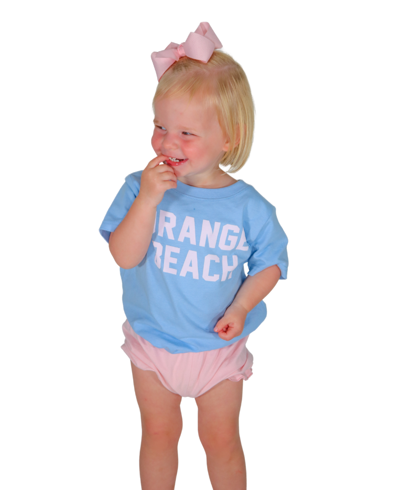 Child wearing a blue shirt with 'Orange Beach' text and pink shorts on a white background