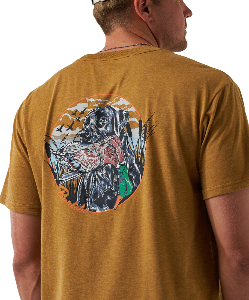 Man wearing a light brown t-shirt with a black dog and duck graphic on the back.