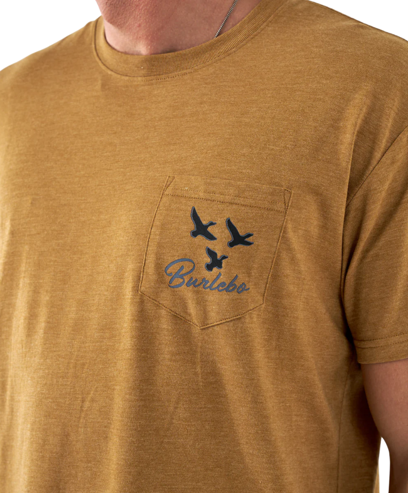 Close-up of a light brown t-shirt with a pocket design featuring birds and text.