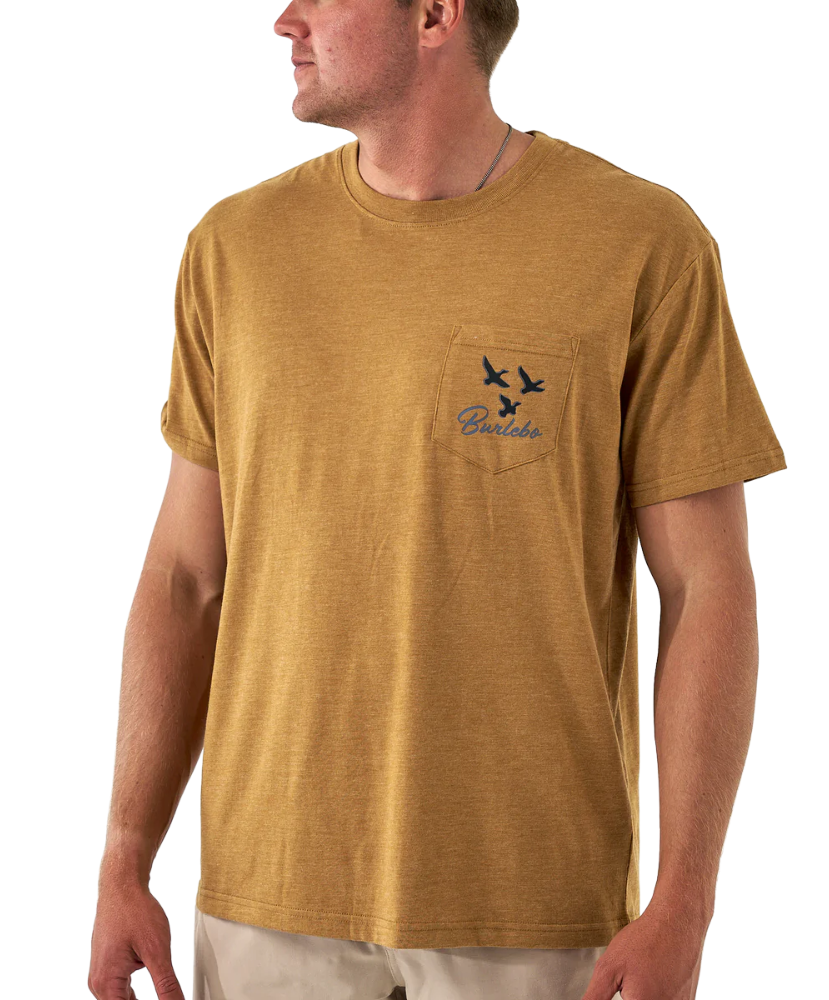 Man wearing a light brown t-shirt with a brand logo on a white background