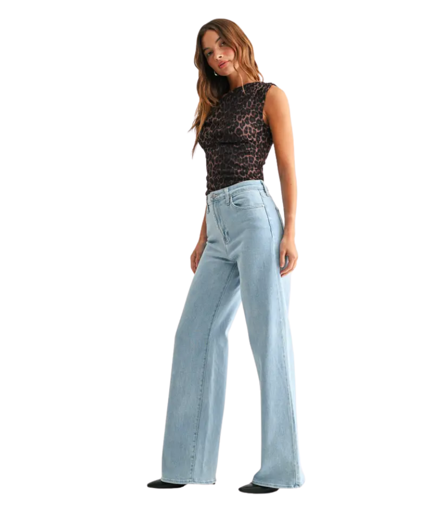 Woman wearring light denim pants with a high rise and wide leg