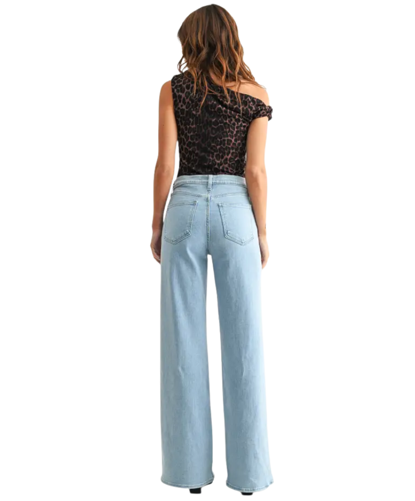 Woman wearring light denim pants with a high rise and wide leg