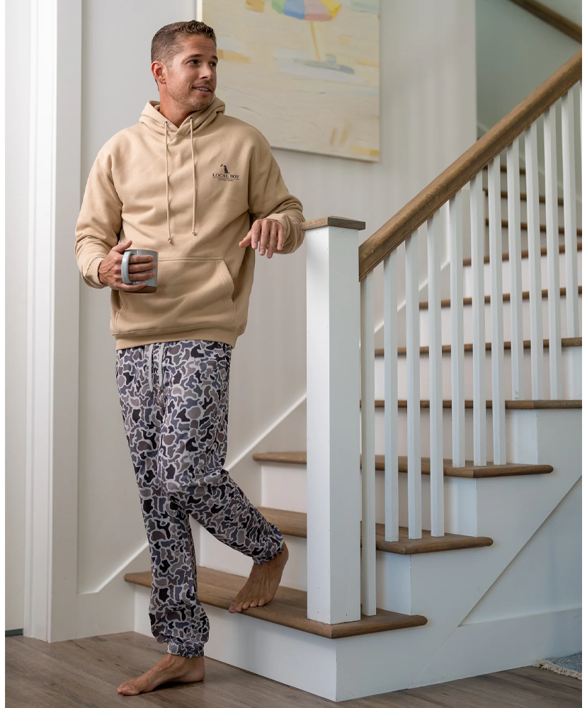 A pair of men's joggers with a camouflage pattern in muted colors.