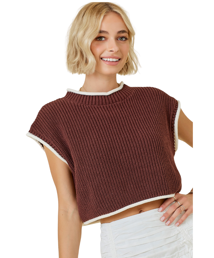 Woman wearing a brown knitted top with white trim on a white background