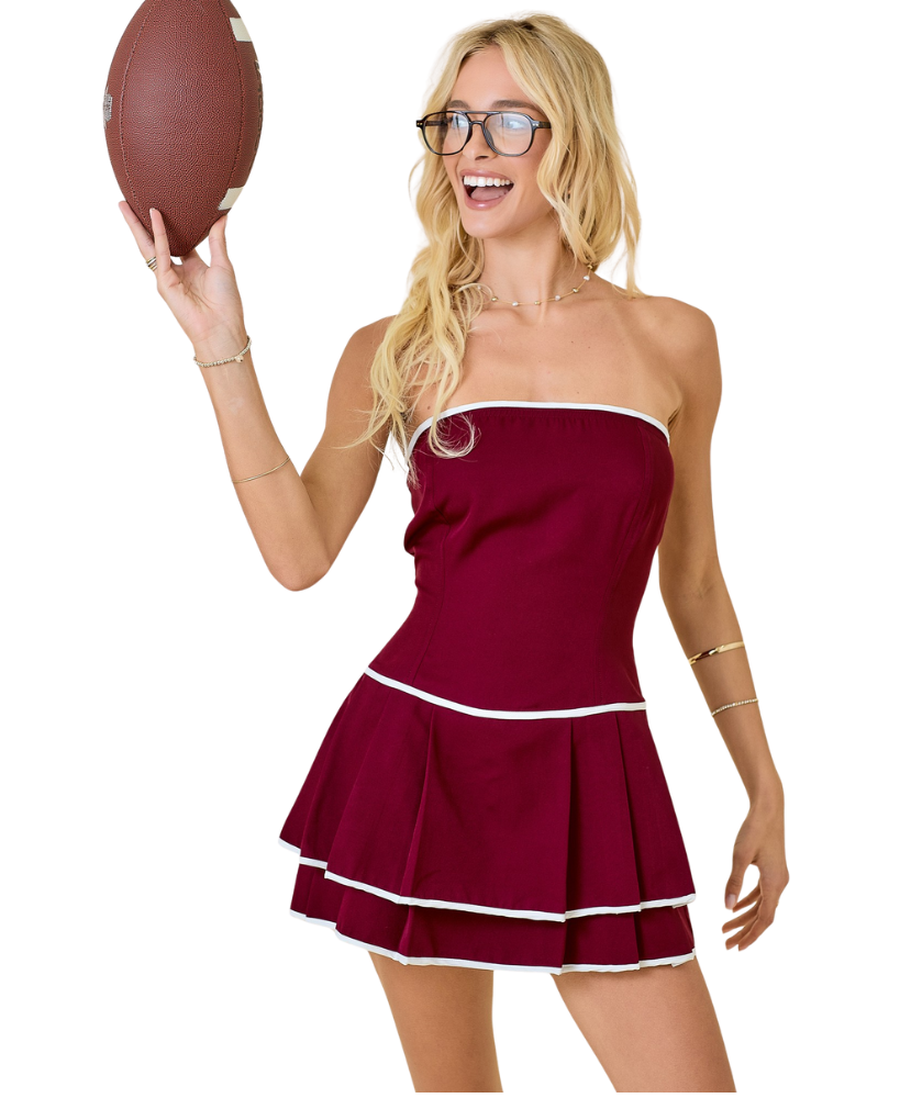 Woman in a red dress holding a football on a white background