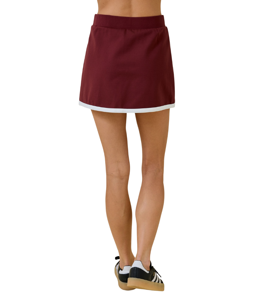 Maroon skirt worn by a person on a white background