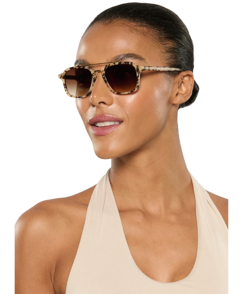 Woman wearing tortoiseshell Krewe sunglasses on a white background