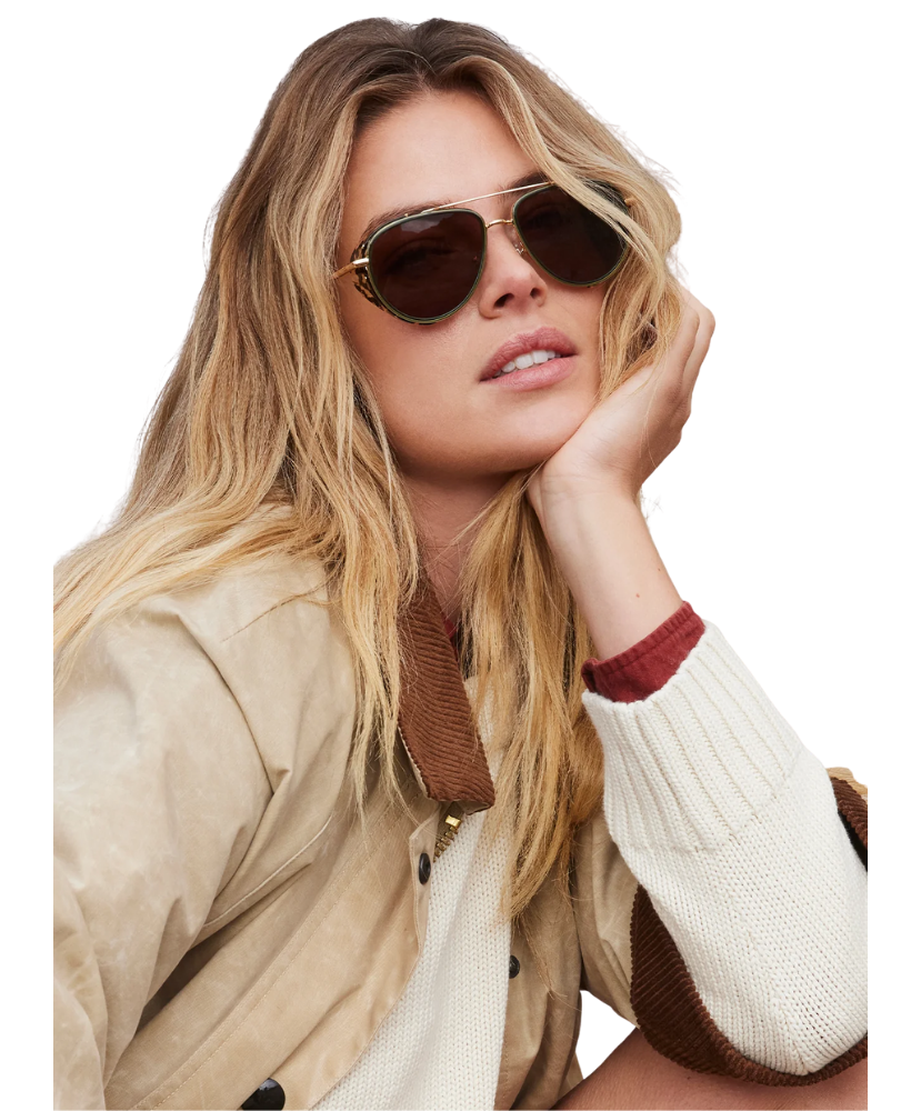 Woman wearing Krewe sunglasses with a neutral background