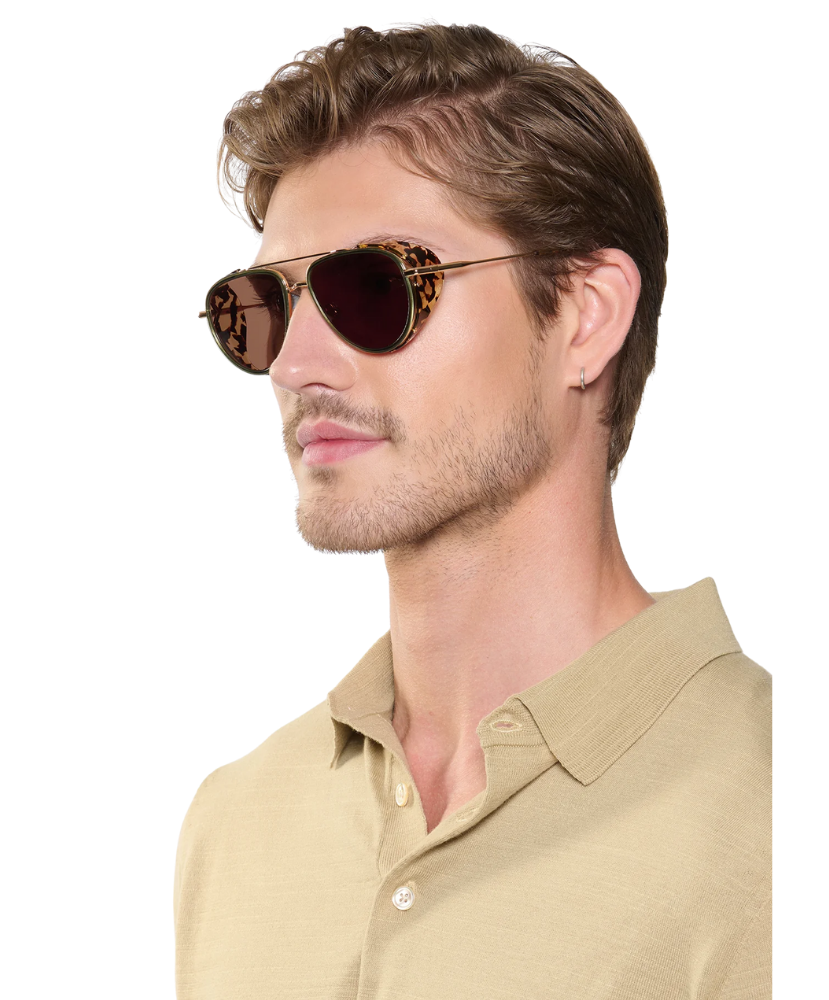 Man wearing a beige shirt and Krewe sunglasses on a white background