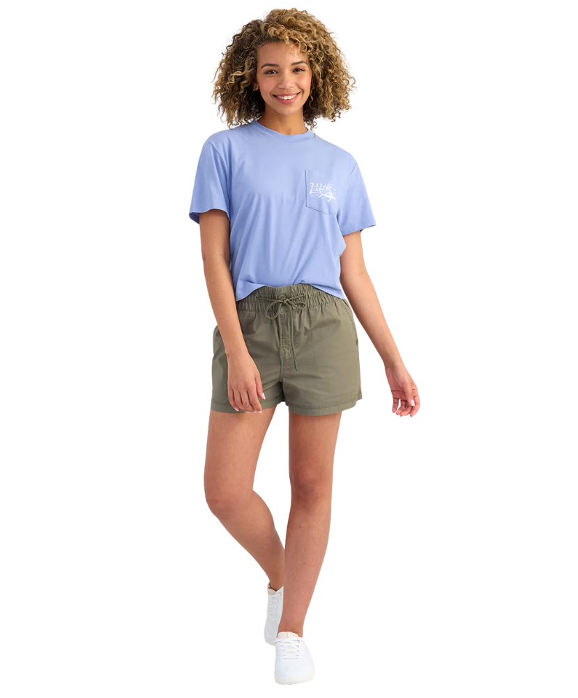 Woman wearing a light blue t-shirt and green shorts on a white background
