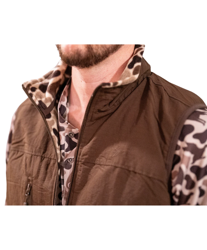 Brown vest with camouflage sleeves worn by a person on a white background