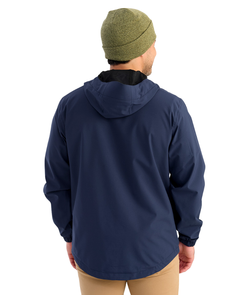 Man wearing a HUK navy jacket with a brand logo on a white background