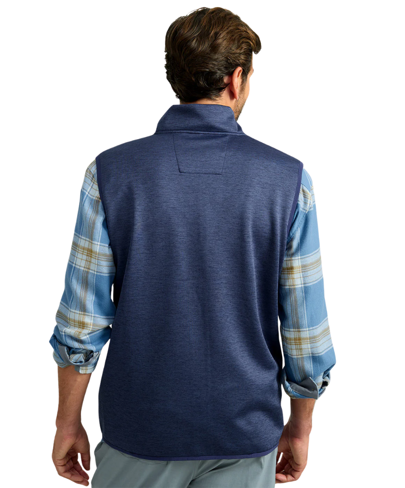 Man wearing a blue fleece vest over a plaid shirt on a white background HUK GEAR VEST