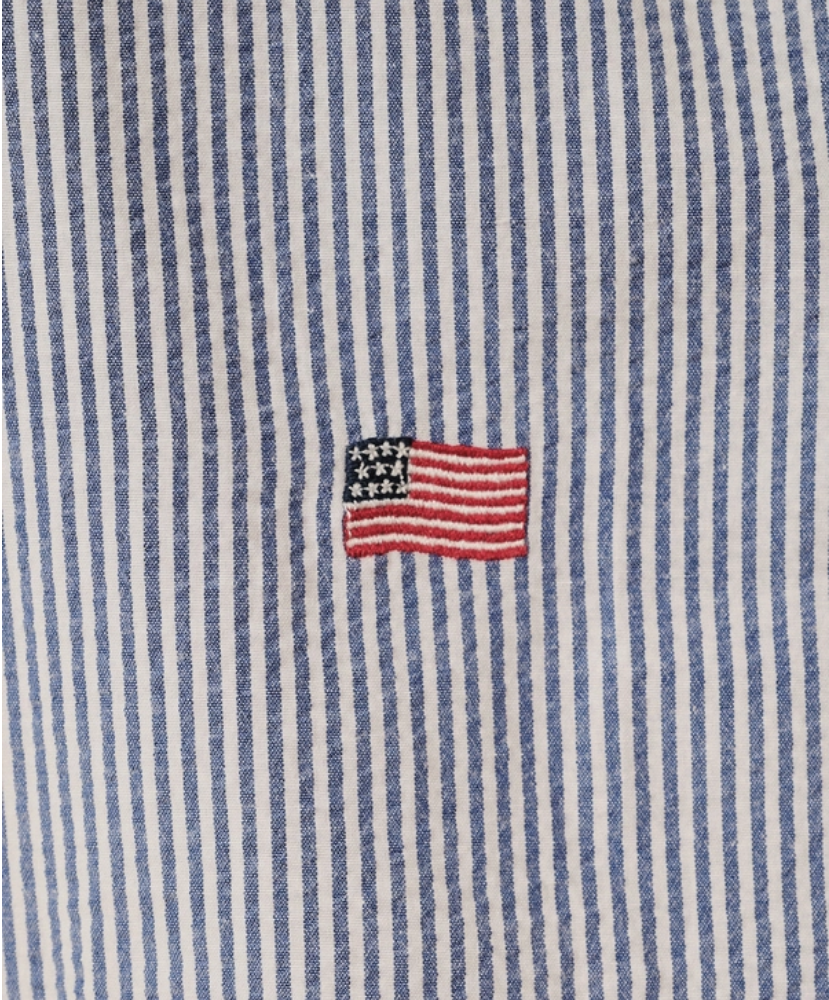 Close-up of a blue and white striped fabric with an embroidered American flag.