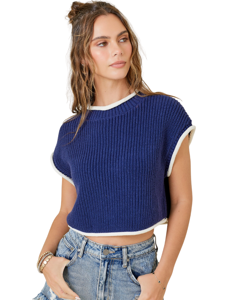 Woman wearing a blue ribbed crop top with white trim on a white background