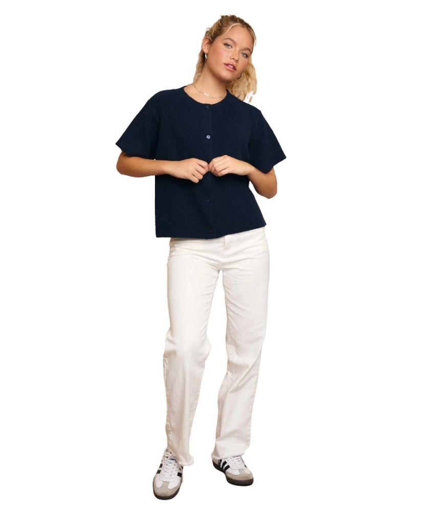Person wearing a navy blue shirt and white pants on a white background