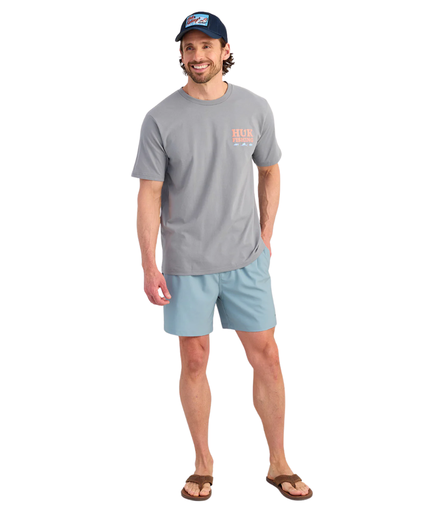 Man wearing a gray t-shirt and light blue shorts on a white background