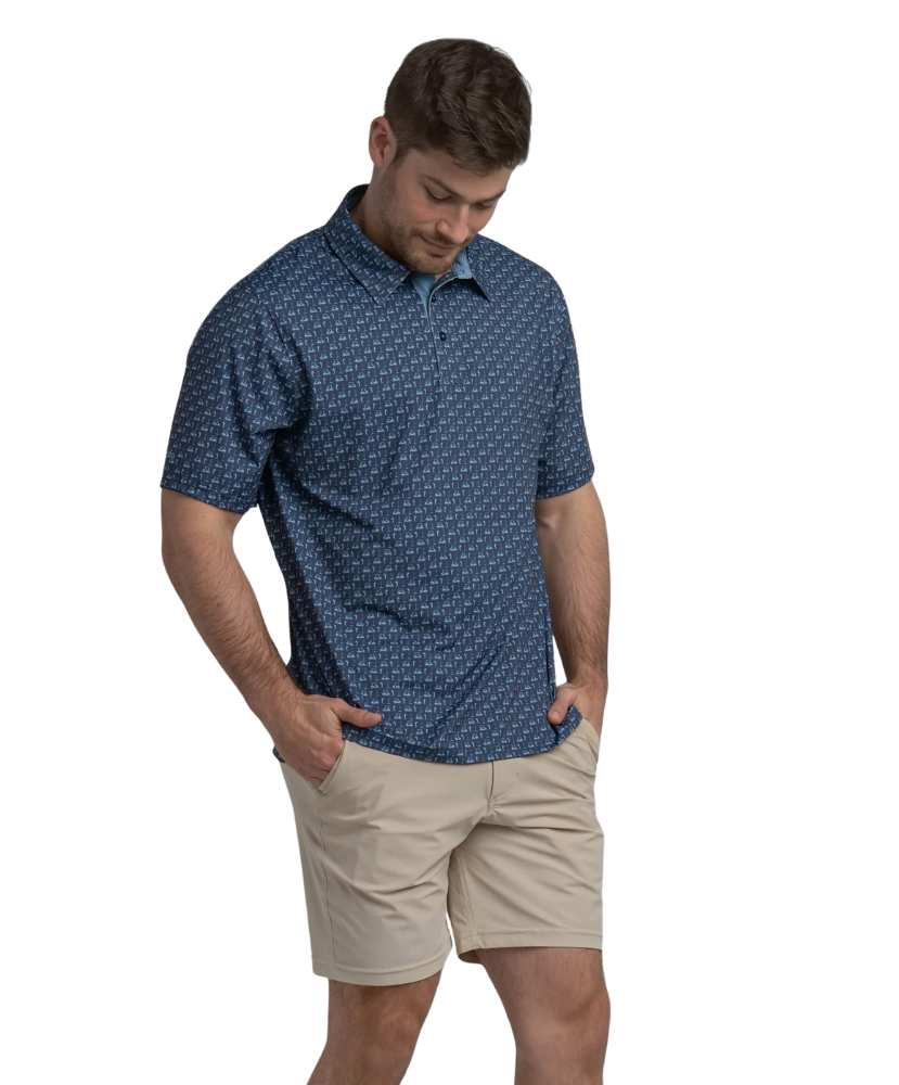 Man wearing a blue golf cart patterned polo shirt and beige shorts on a white background