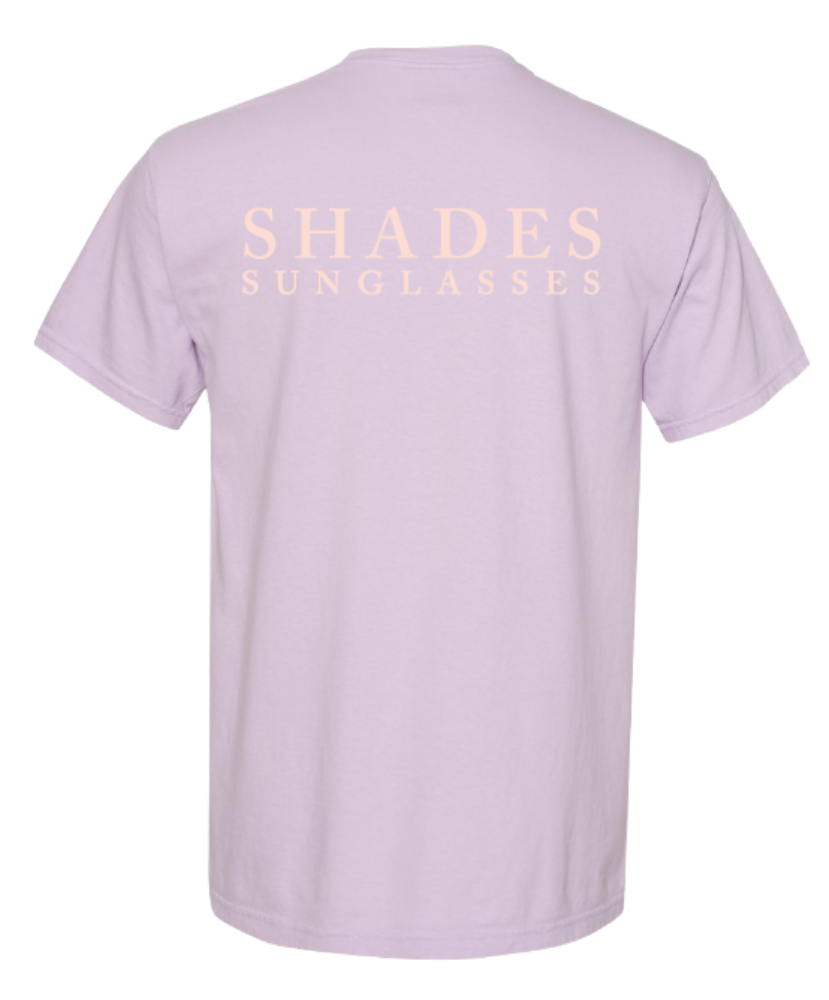 Lavender t-shirt with 'SHADES SUNGLASSES' text on a white background