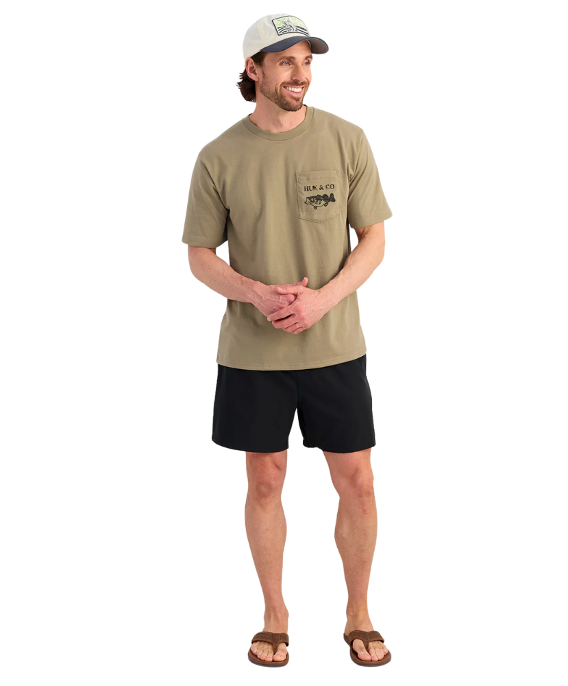 Man wearing a beige t-shirt and black shorts on a white background
