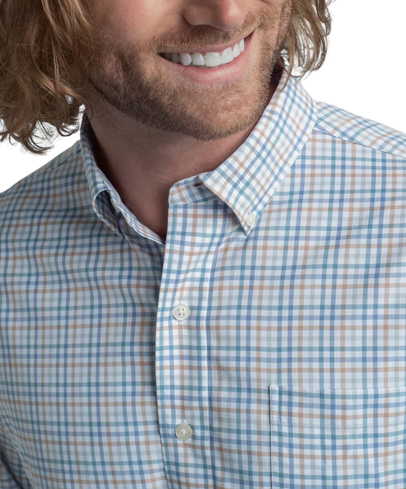 Man wearing a blue and white checkered shirt with a blurred background