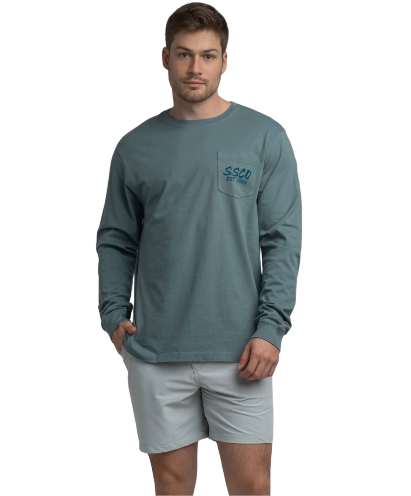 Man wearing a long-sleeve teal shirt with a logo on a white background