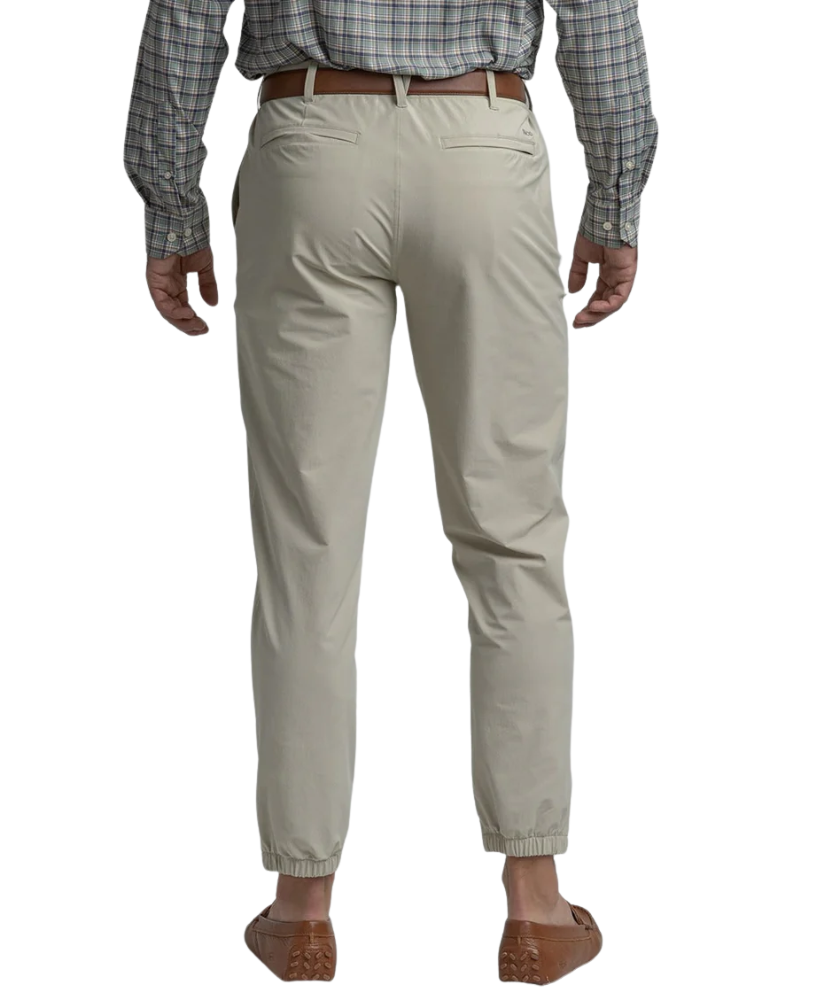 Beige Nomad Performance Jogger pants worn by a person on a white background