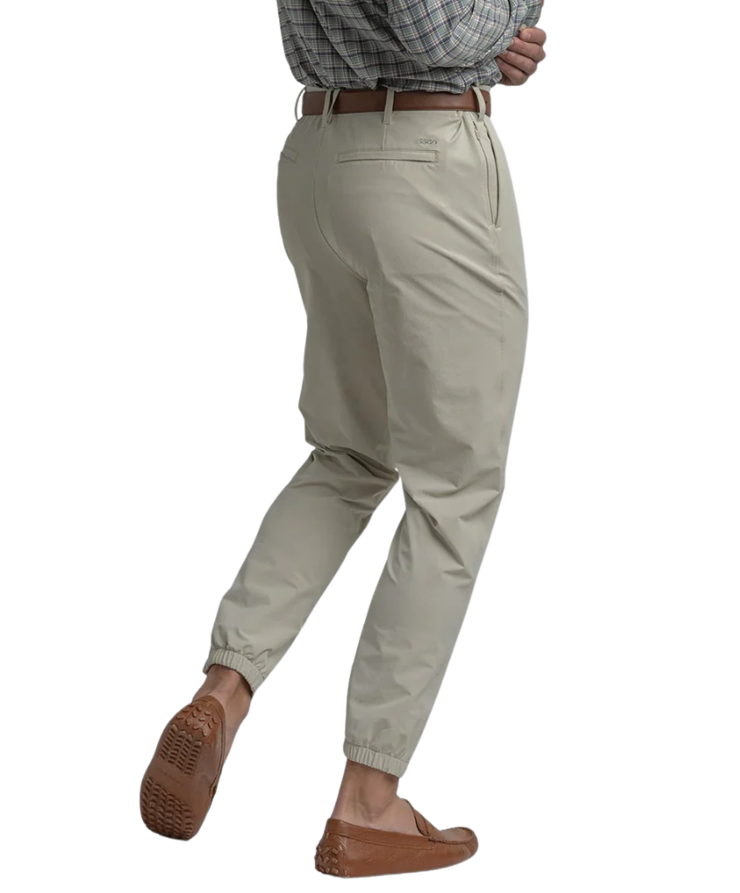 Beige Nomad Performance Jogger pants worn by a person on a white background