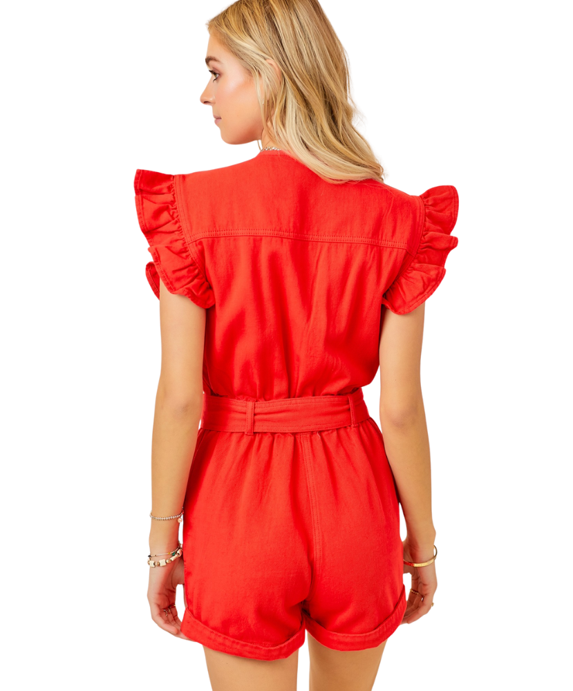 Red romper with ruffled sleeves worn by a person on a white background