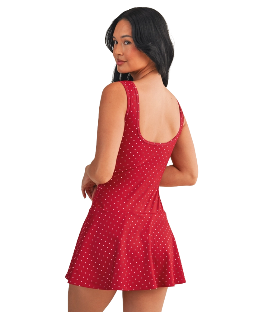 Woman wearing a red polka dot dress on a white background