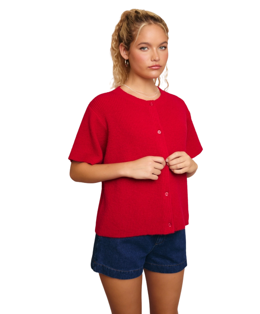 Woman wearing a red cardigan sweater and blue shorts on a white background