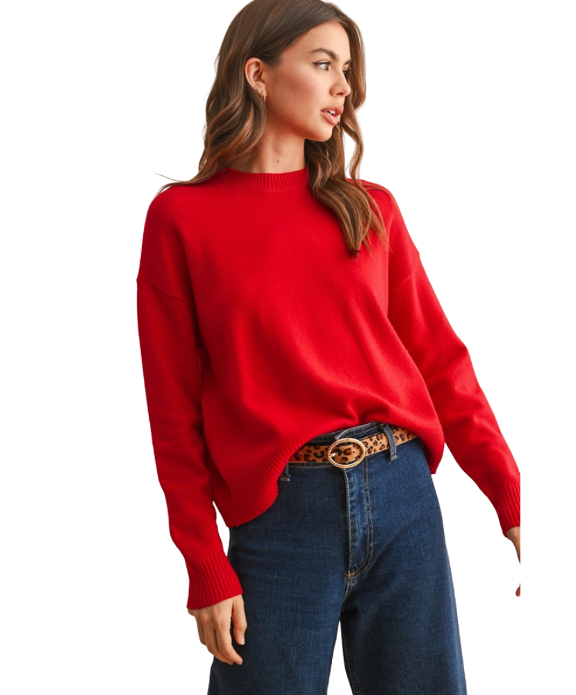 Woman wearing a red sweater and blue jeans on a white background