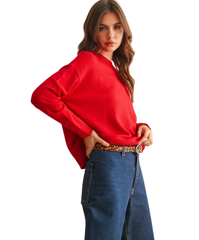 Woman wearing a red sweater and blue jeans on a white background