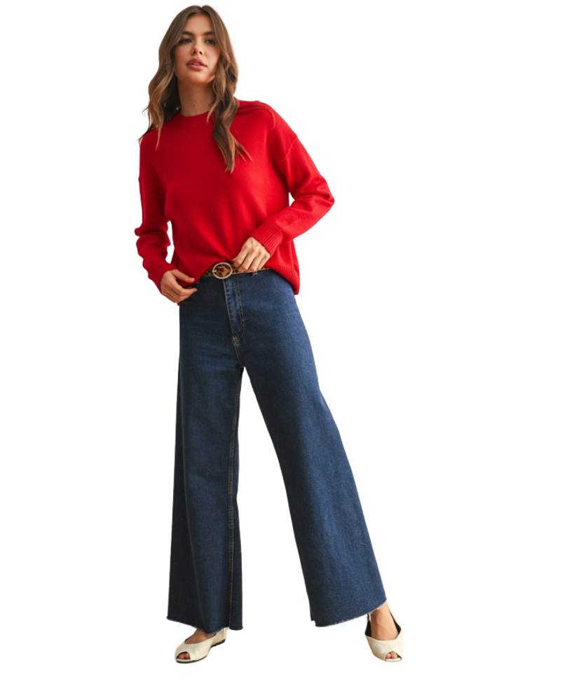 Woman wearing a red sweater and blue jeans on a white background