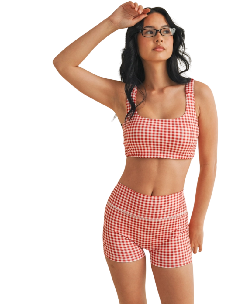 Woman wearing a red and white GINGHAM checkered tsports bra on a white backgrounD