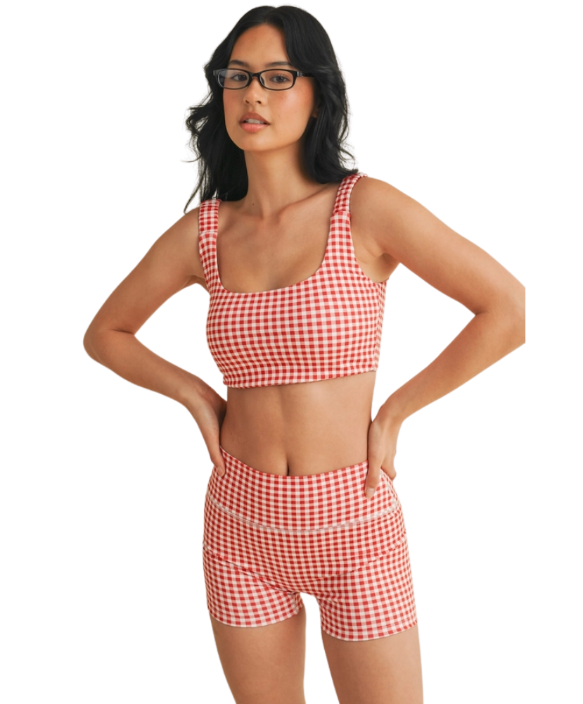 Woman wearing a red and white GINGHAM checkered tsports bra on a white backgrounD