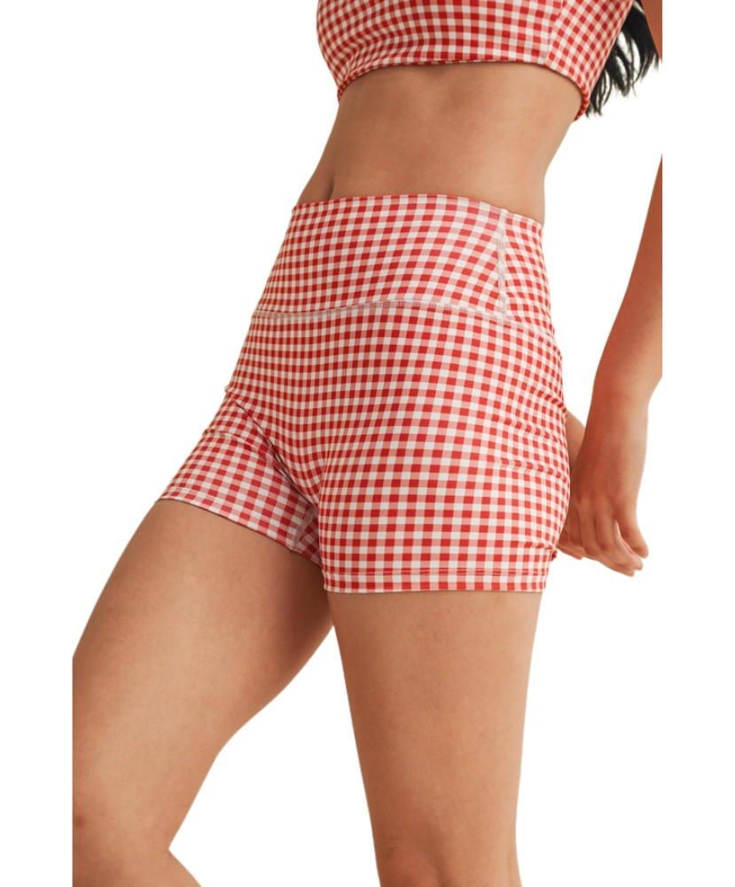 Woman wearing a red and white gingham checkered shorts on a white background