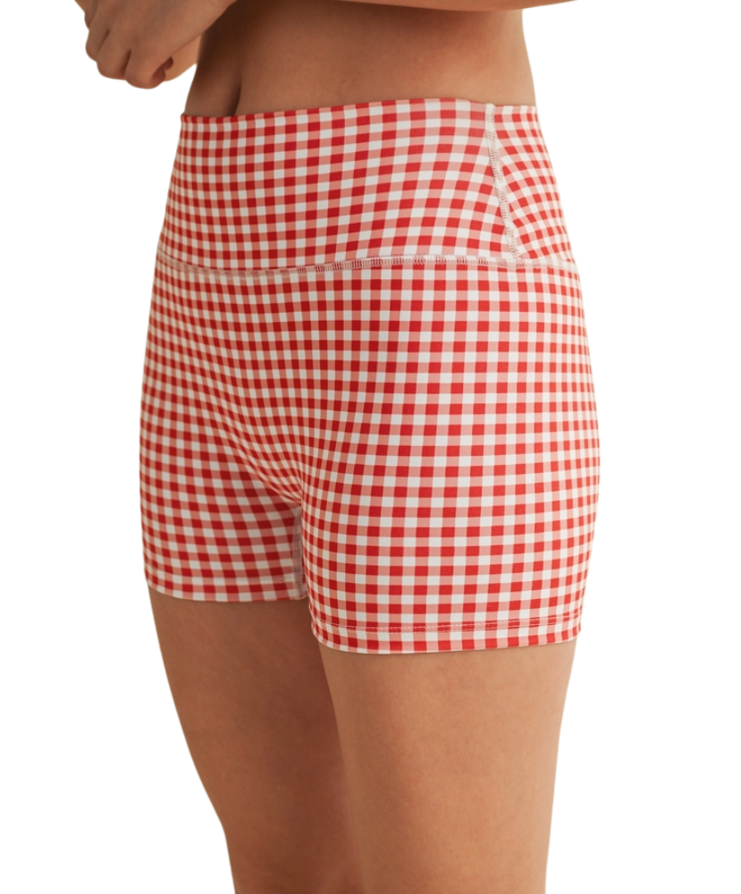 Woman wearing a red and white gingham checkered shorts on a white background