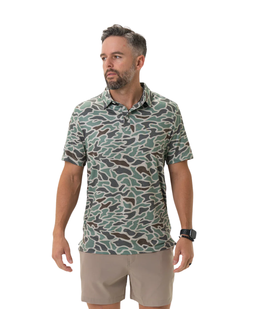 Man wearing a camouflage-patterned polo on a white background