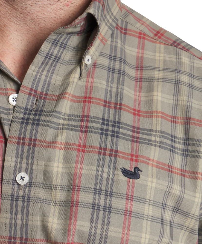 Man wearing a Southern Marsh plaid shirt and dark pants on a white background