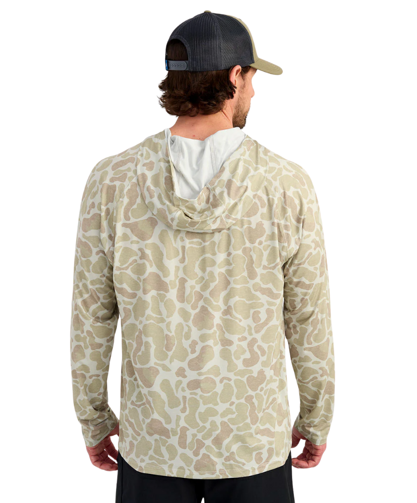 Man wearing a sand camouflage-patterned hoodie on a white background