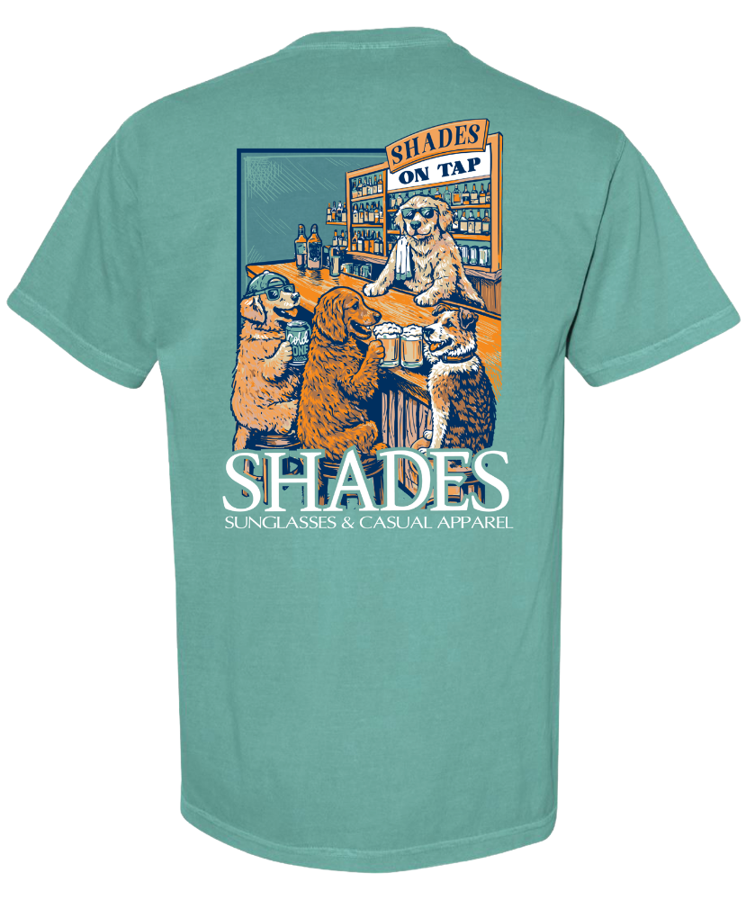 Teal t-shirt with a graphic of dogs at a bar and 'Shades' branding on a white background